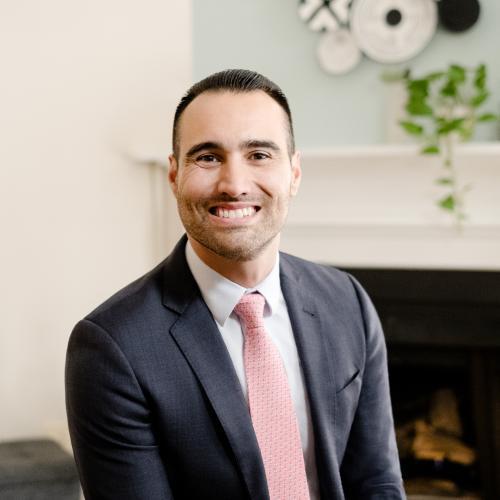 Jorge Burmicky, Ph.D. poses for a professional headshot wearing a dark grey suit with pink tie.