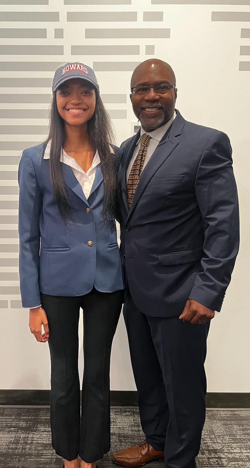 A Howard University student on the left smiling next to her mentor on the right. Both are wearing professional suits