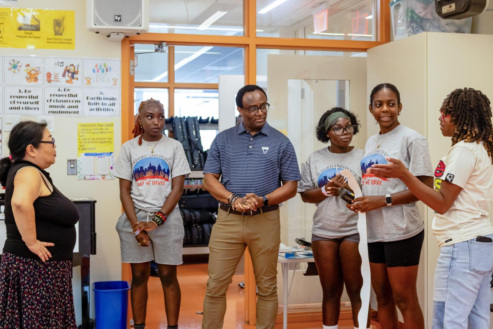 Six people standing in an elementary school classroom. 