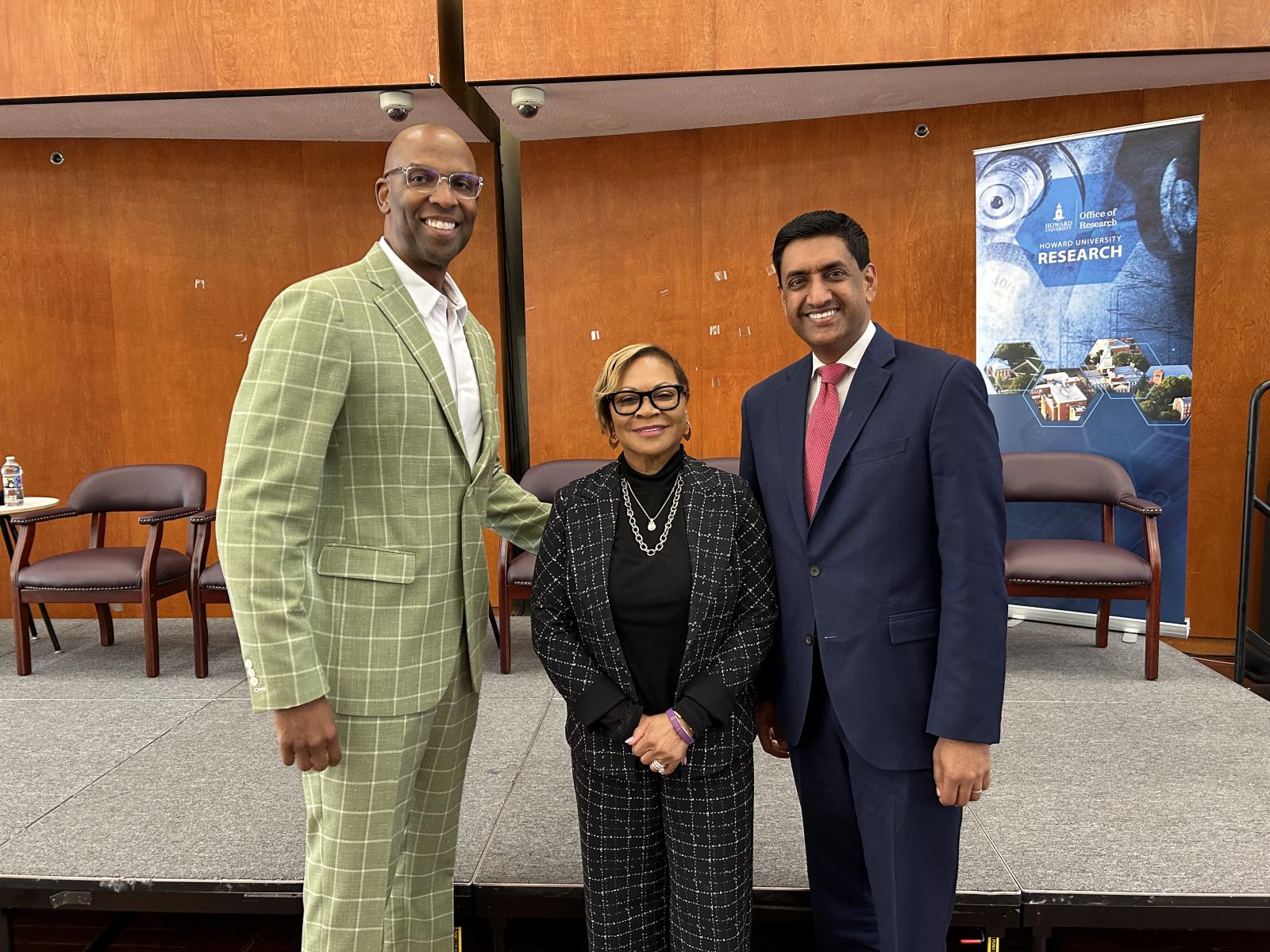 Three people standing near a stage