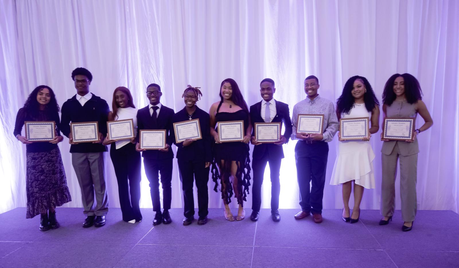 10 Howard University students holding a certificate in their hands
