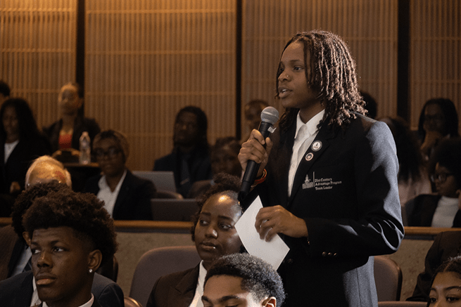 Student in the audience asking question during the lecture series