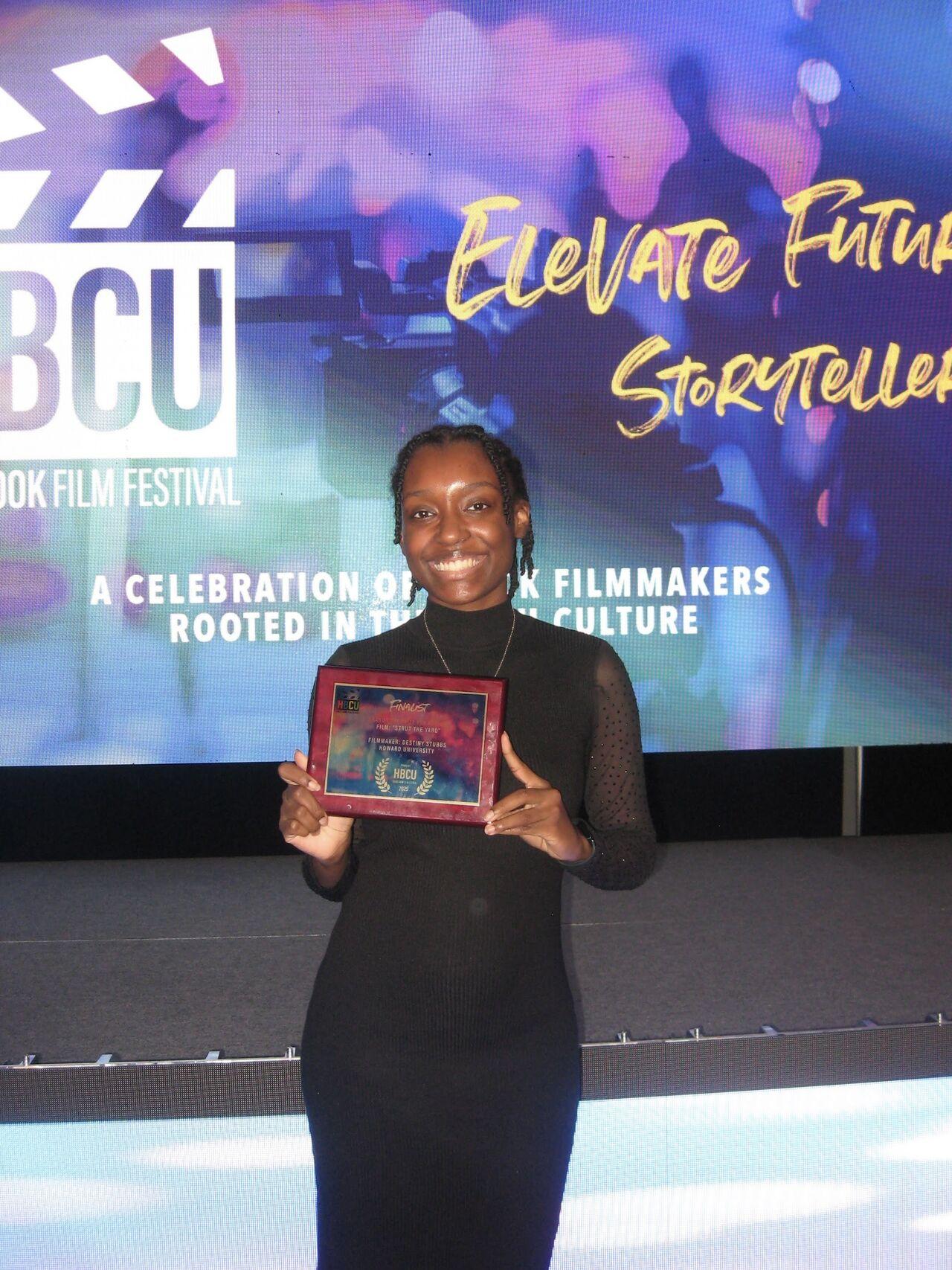 A person holding a plague, smiling at the camera