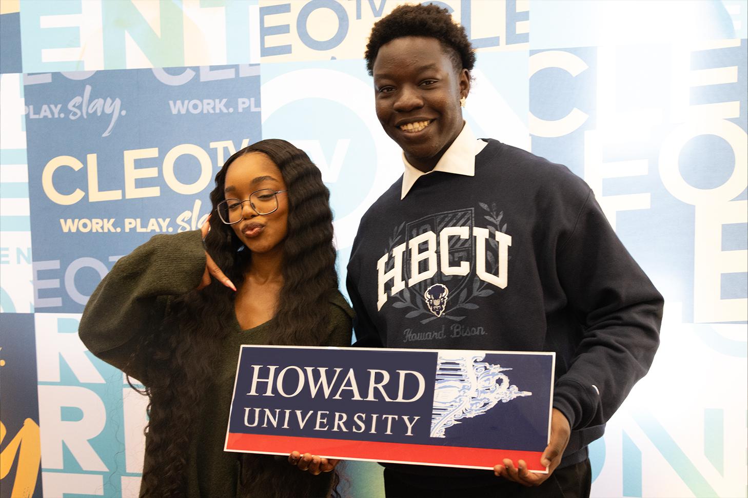Two people holding howard university sign