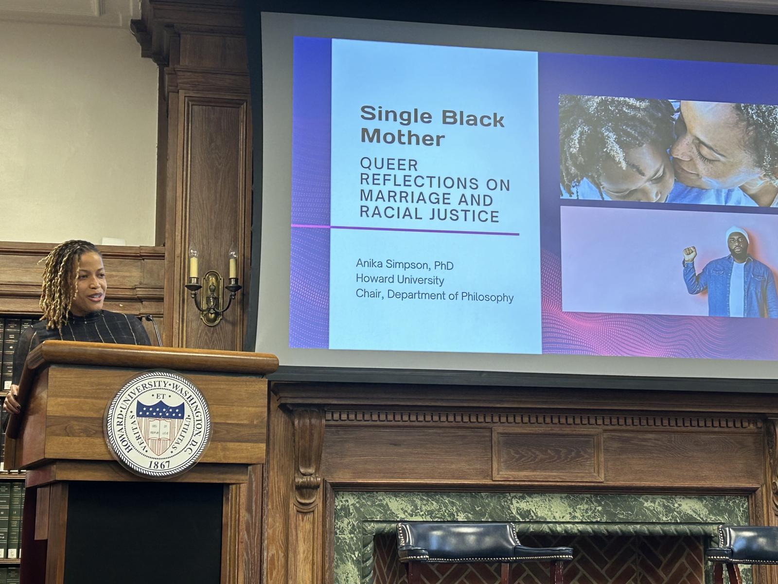 A woman standing behind a podium with Howard University's logo on it. 