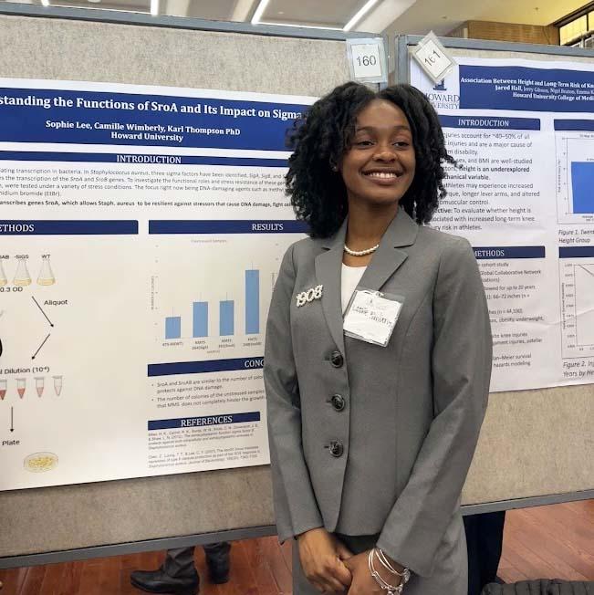 Camille Wimberly standing in front of poster board with research findings on it