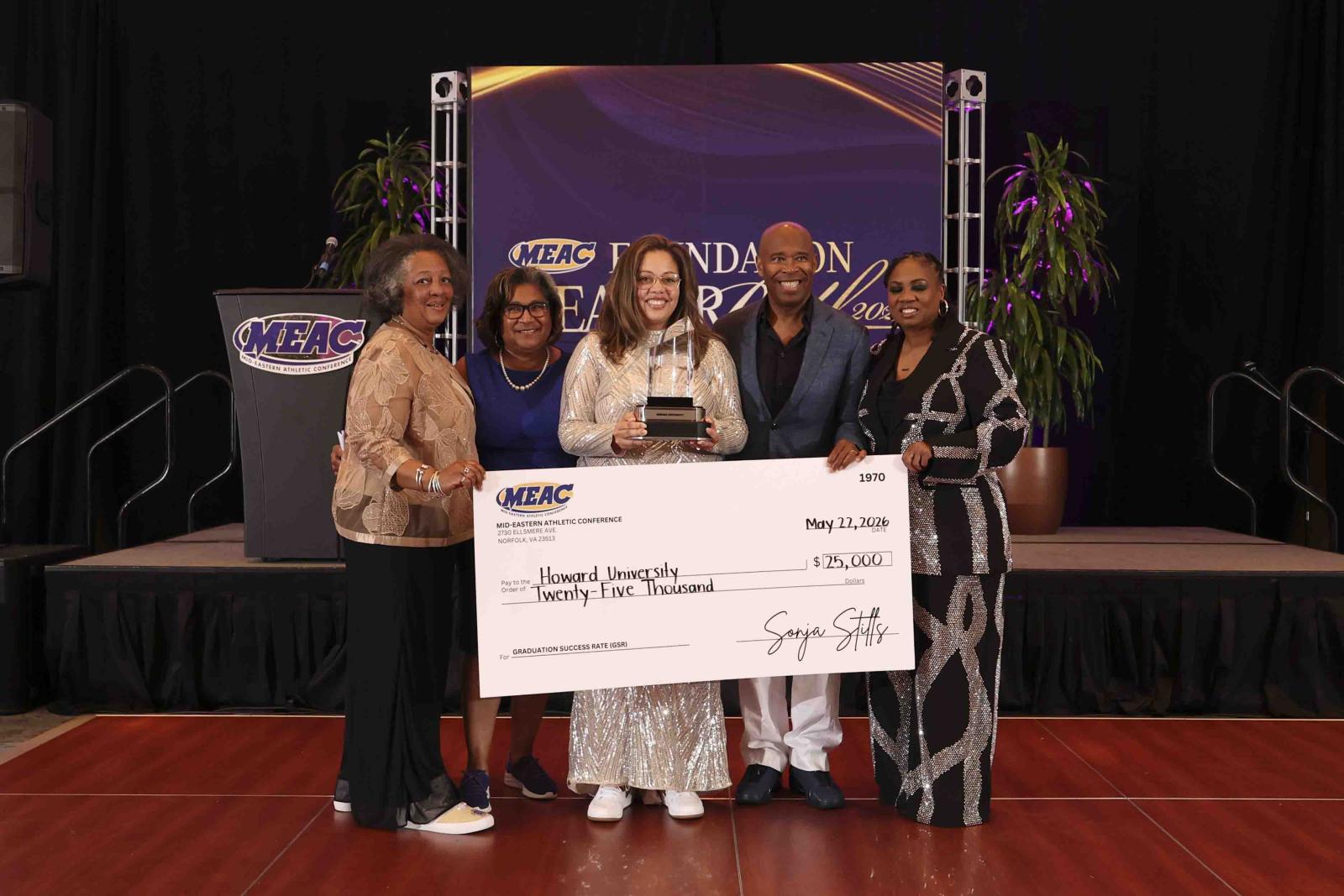MEAC Sneakerball 2026 event. Four people holding a large check made out to Howard University