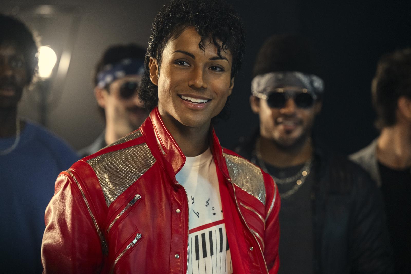 Jaafar Jackson playing the role of Michael Jackson in the Michael movie. Jaafar is in the foreground while three other men are behind him in the background