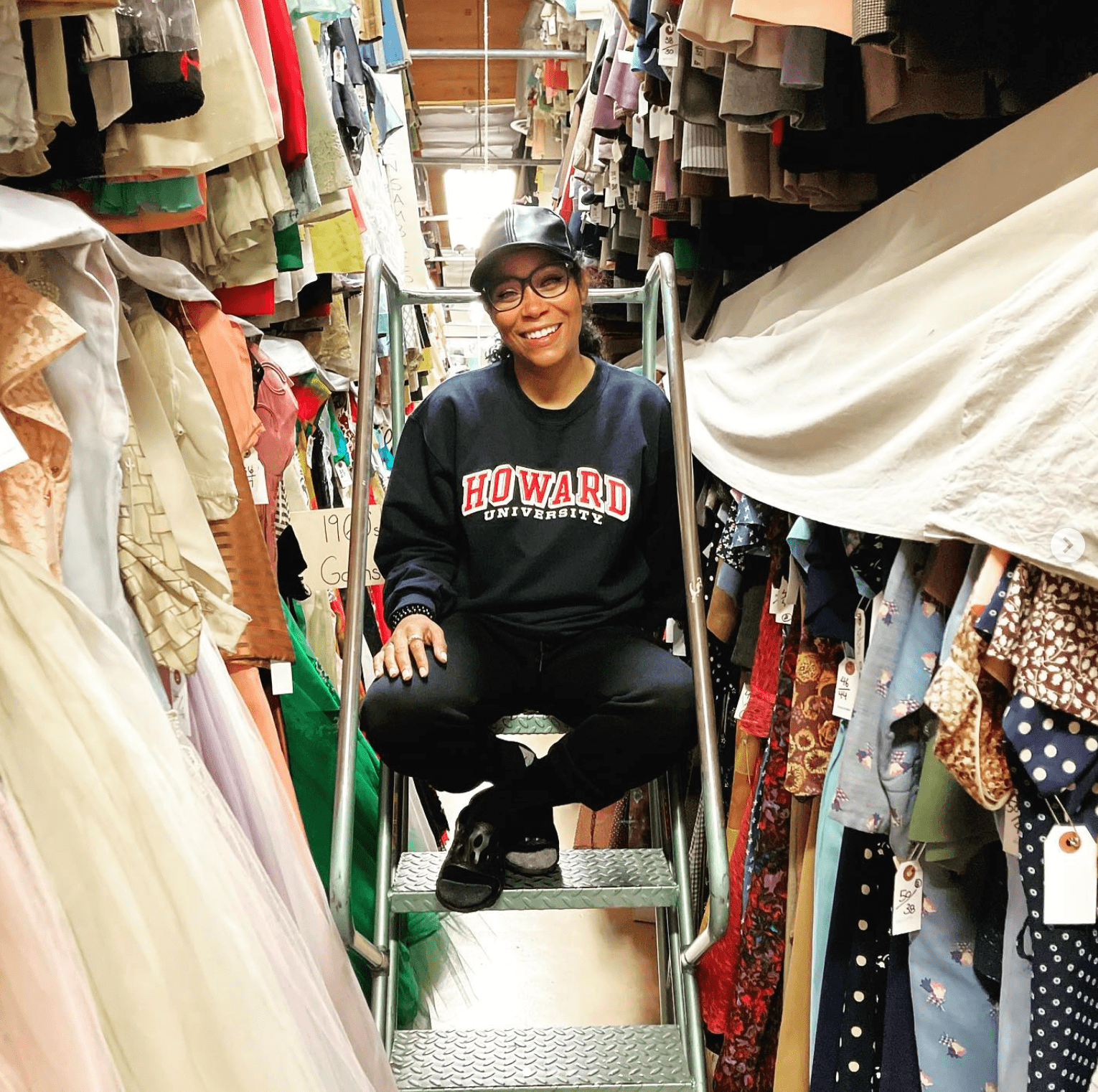 Marci Rodgers sitting on a step ladder in a large wardrobe closet