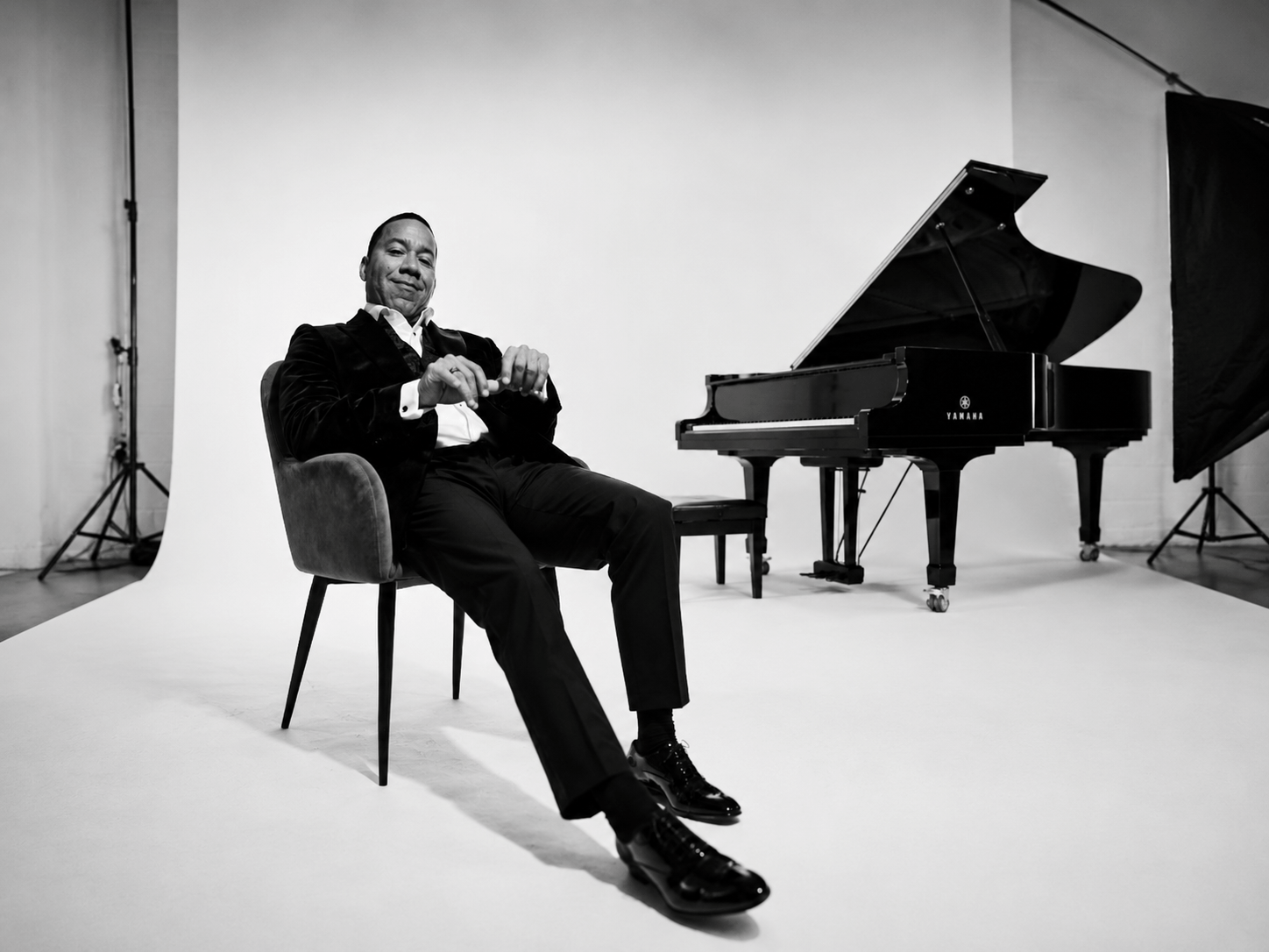 Marcus Jonhson in Black and White with a piano in the background