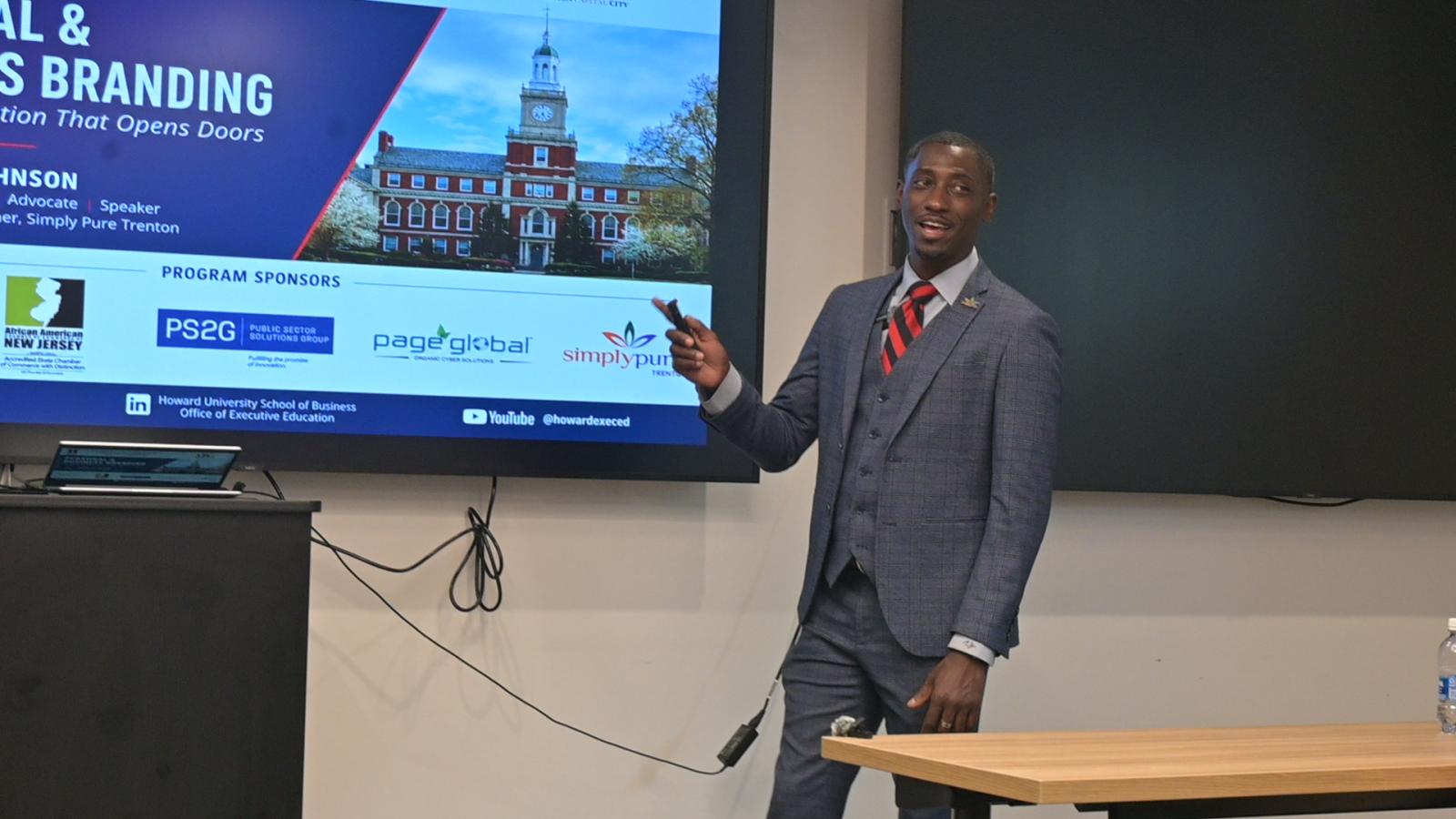 Tahir Johnson standing next to a projector screen