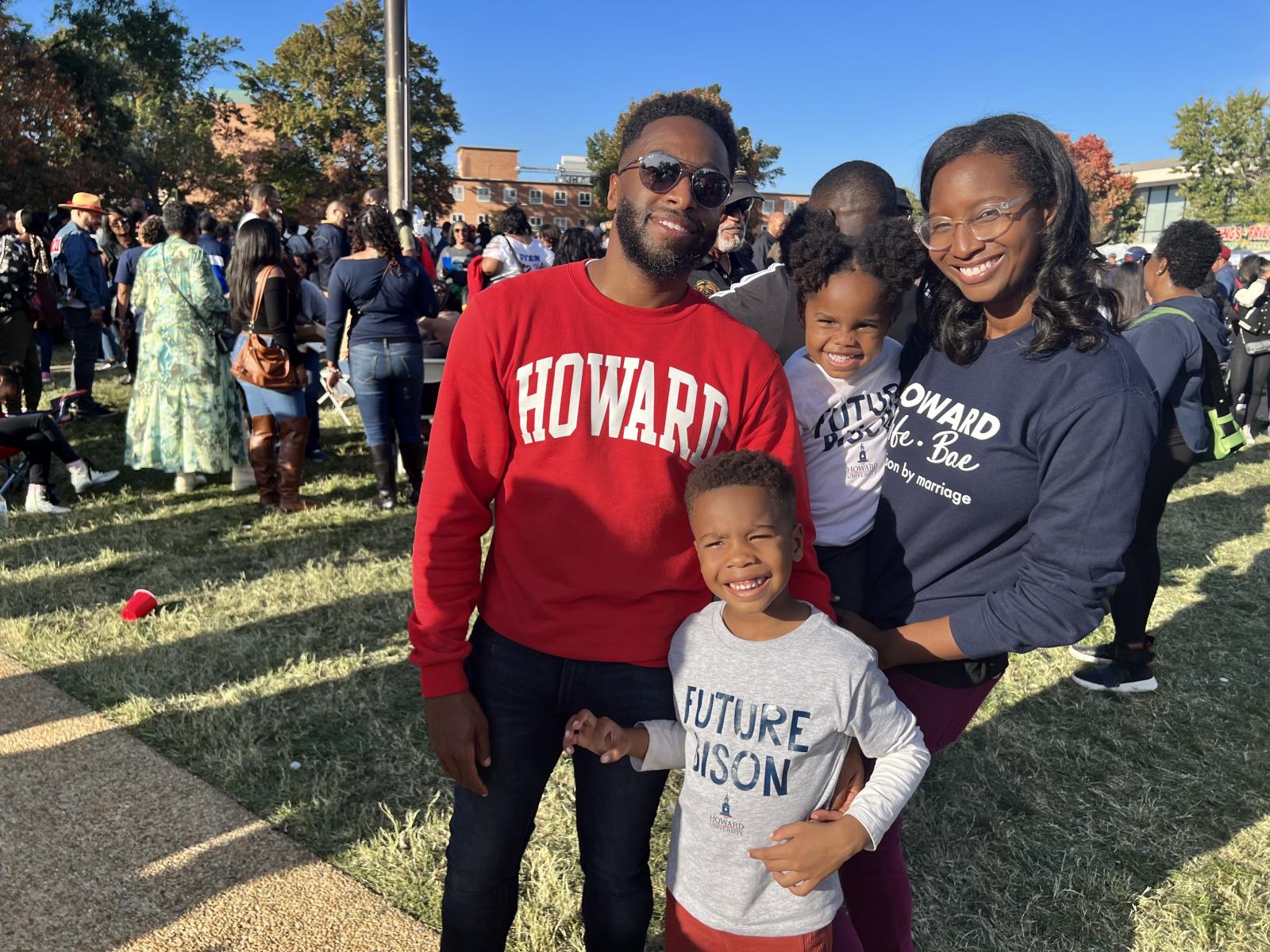 A family of four wearing Howard University paraphernalia outside on Howard's campus 