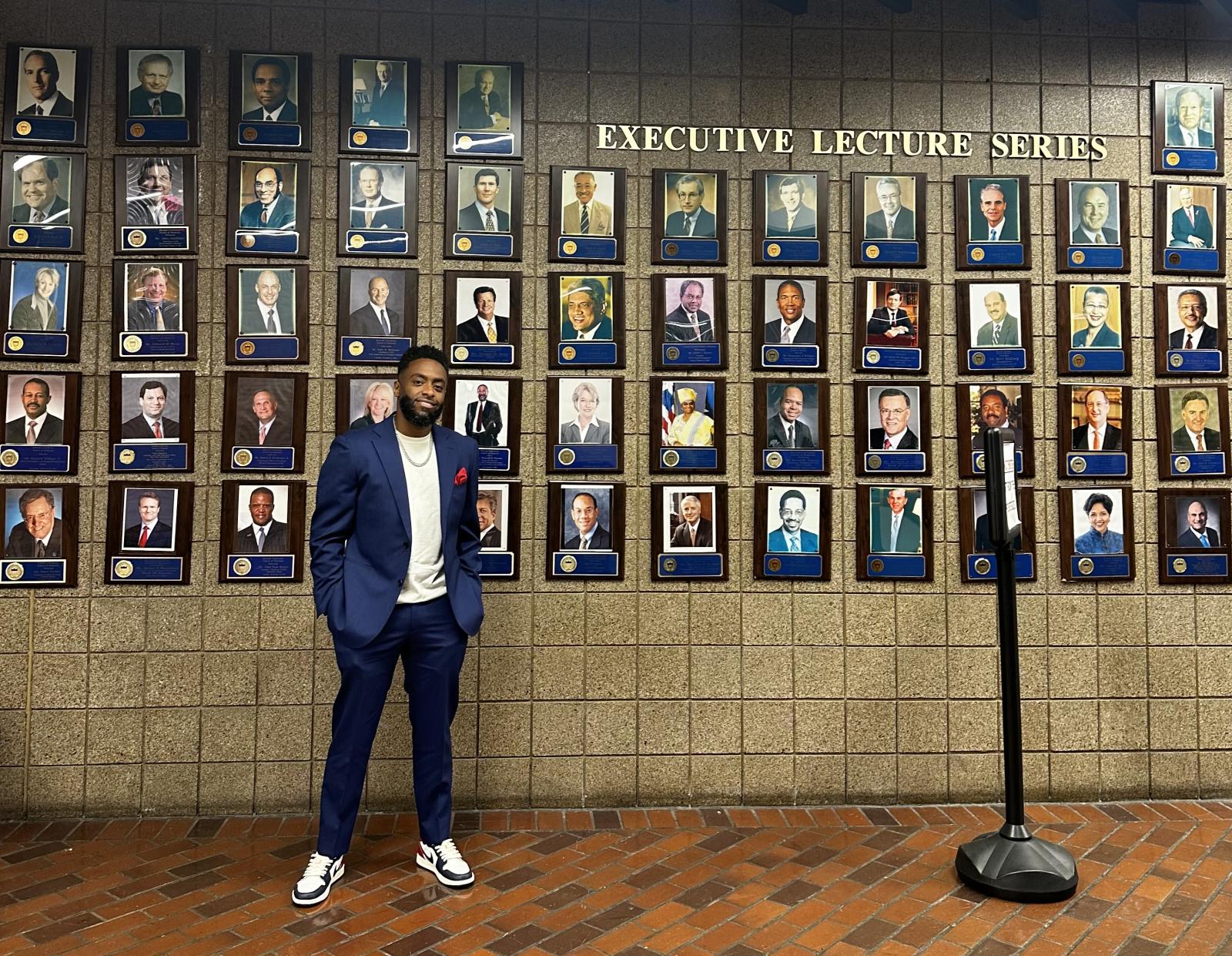 Chequan Lewis standing next to a series of photographs on a wall