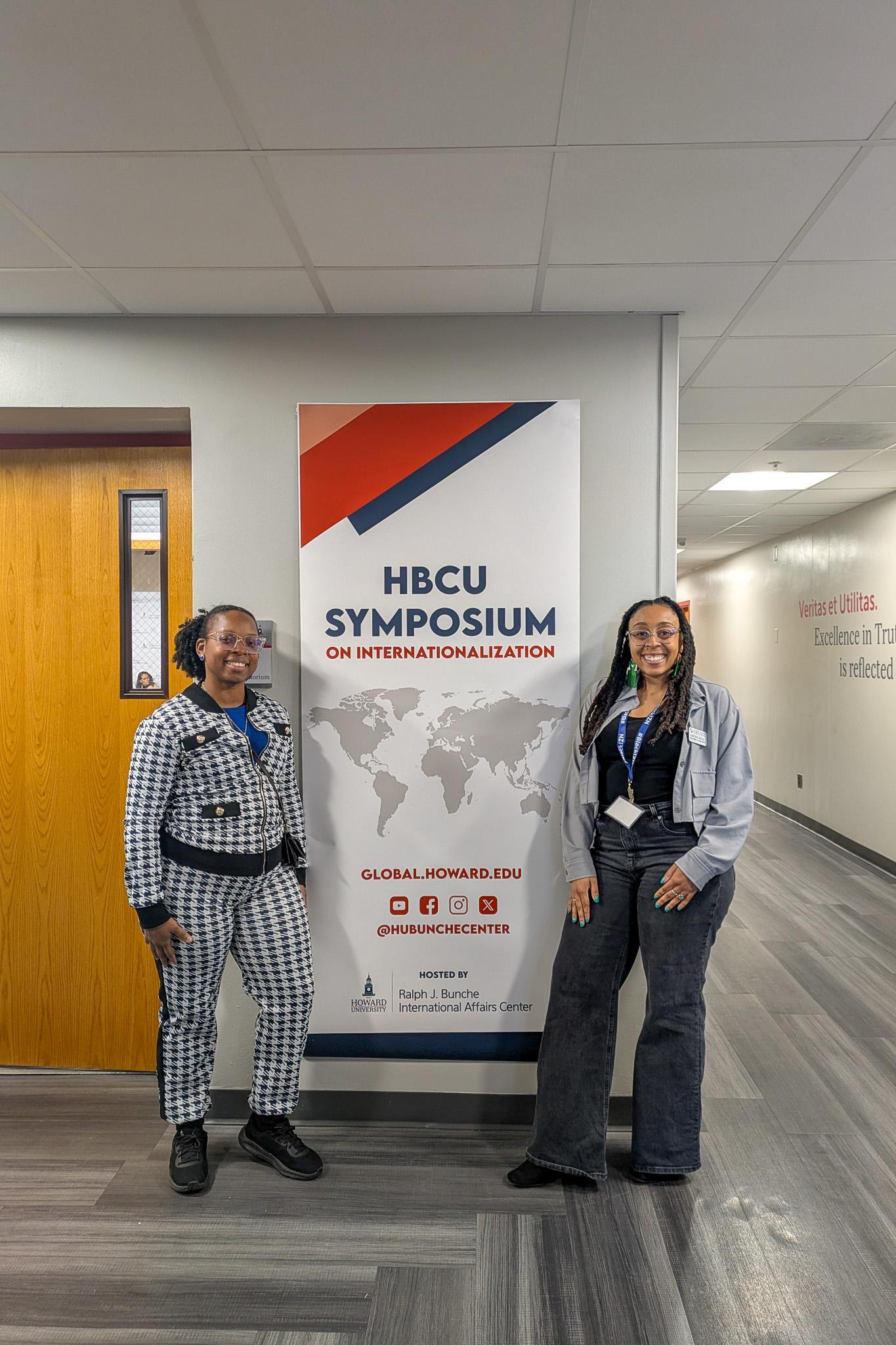 Two attendees at the HBCU Symposium on Internationalization in 2025 standing in front of a poster