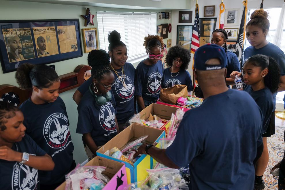 Howard students passing out plates to veterans at Access Housing Inc. wearing blue Student Veterans of America shirts