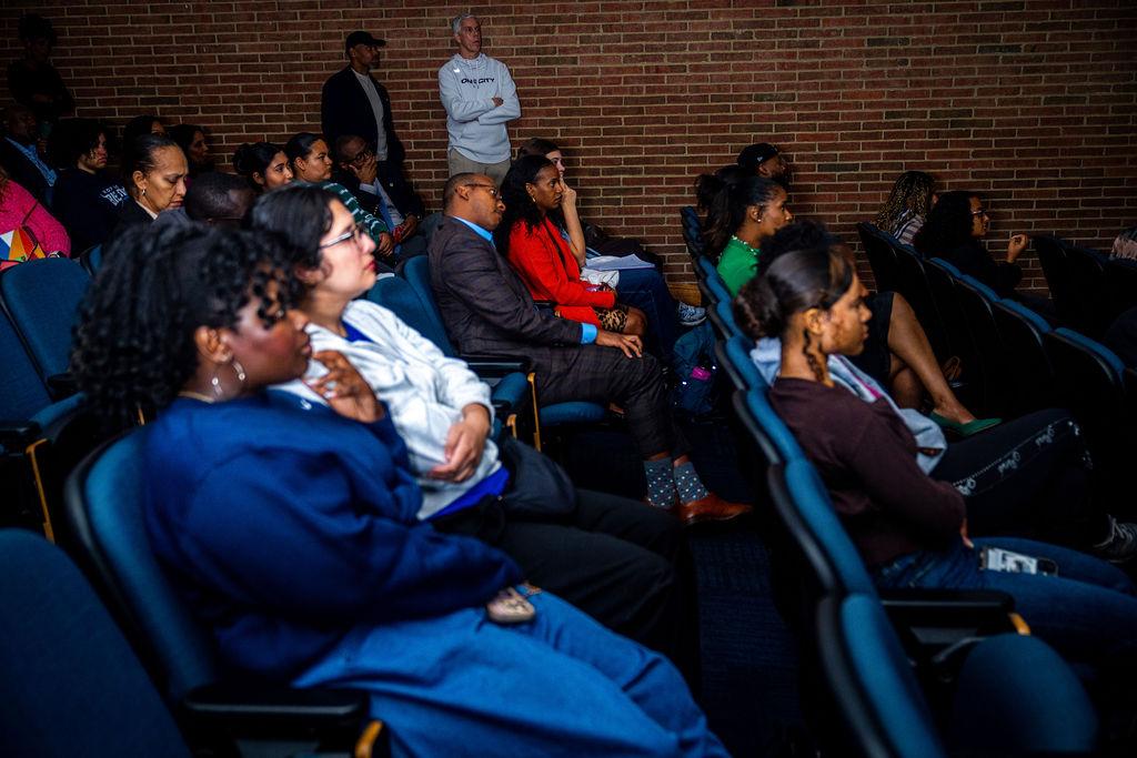 Audience at Howard University screening of "How to Change the World" documentary at the Blackburn Digital Auditorium with several students talking