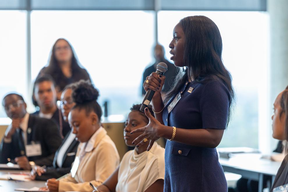 Howard students visit Marriott International and female student in a blue dress asks a question