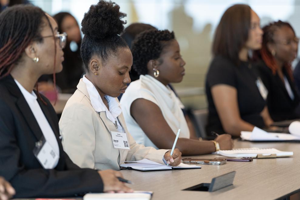 Howard University students seated side by side at panel at Marriott International listening to speakers