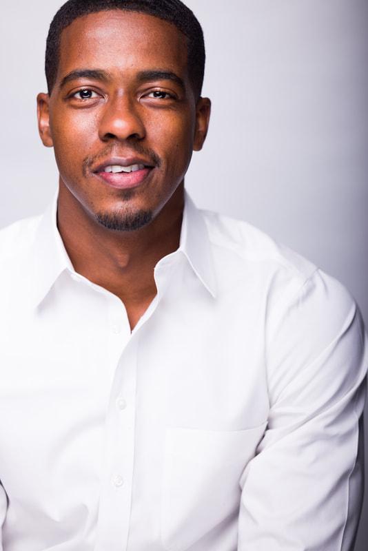 Howard instructor and actor Derrick A. King wearing a white buttoned-down shirt